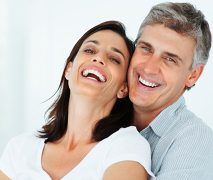 Middle-aged couple smile with their mouths partially open - for information on zirconia crowns