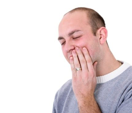 Man holding the side of his mouth, portraying tooth injury and need for a veneer