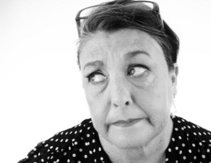 Woman portraying concern over uncomfortable dentures and replacing them with overdentures